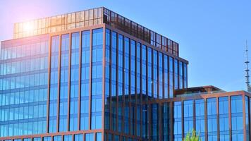 Glass building with transparent facade of the building and blue sky. Structural glass wall reflecting blue sky. Abstract modern architecture fragment. Contemporary architectural background. photo