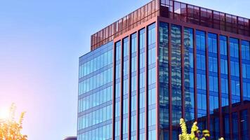 Glass building with transparent facade of the building and blue sky. Structural glass wall reflecting blue sky. Abstract modern architecture fragment. Contemporary architectural background. photo