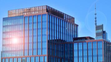 Glass building with transparent facade of the building and blue sky. Structural glass wall reflecting blue sky. Abstract modern architecture fragment. Contemporary architectural background. photo