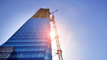 High rise building under construction. Installation of glass facade panels on a reinforced concrete structure. photo