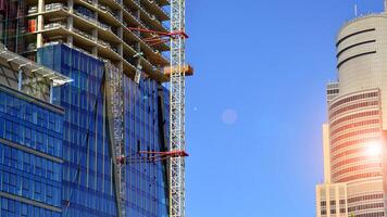 High rise building under construction. Installation of glass facade panels on a reinforced concrete structure. photo