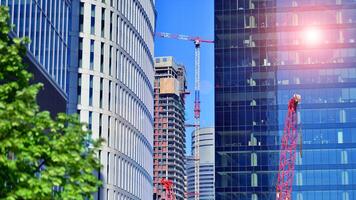 High rise building under construction. Installation of glass facade panels on a reinforced concrete structure. photo