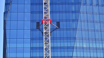 High rise building under construction. Installation of glass facade panels on a reinforced concrete structure. photo