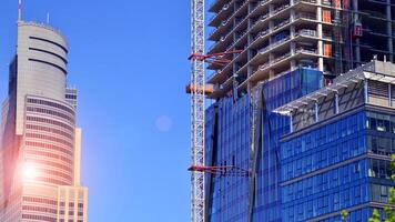 High rise building under construction. Installation of glass facade panels on a reinforced concrete structure. photo