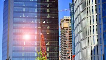 High rise building under construction. Installation of glass facade panels on a reinforced concrete structure. photo