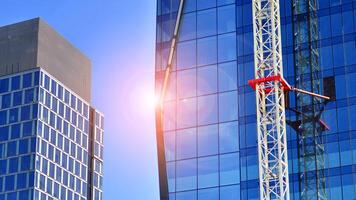 High rise building under construction. Installation of glass facade panels on a reinforced concrete structure. photo