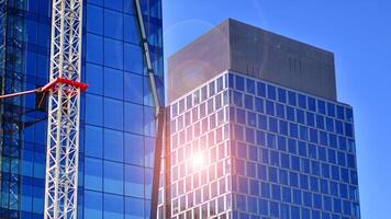 High rise building under construction. Installation of glass facade panels on a reinforced concrete structure. photo