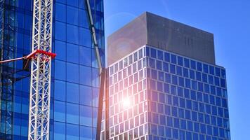 High rise building under construction. Installation of glass facade panels on a reinforced concrete structure. photo