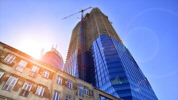 High rise building under construction. Installation of glass facade panels on a reinforced concrete structure. photo