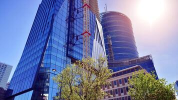 High rise building under construction. Installation of glass facade panels on a reinforced concrete structure. photo