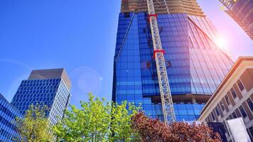 High rise building under construction. Installation of glass facade panels on a reinforced concrete structure. photo