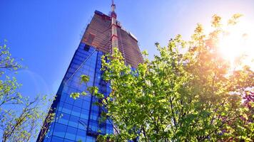 High rise building under construction. Installation of glass facade panels on a reinforced concrete structure. photo