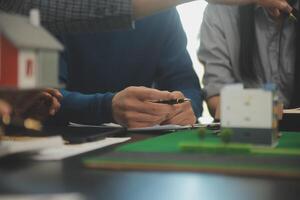 Team of architectures and businessmen discussing and brainstorming on floor plan modification for real estate investment and housing development project photo