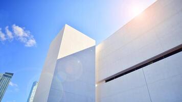 Sunlight and shadow on surface of white Concrete Building wall against blue sky background, Geometric Exterior Architecture in Minimal Street photography style photo