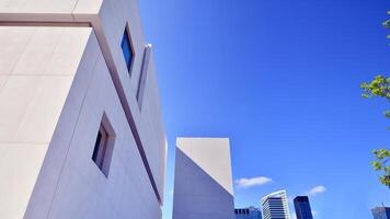 Sunlight and shadow on surface of white Concrete Building wall against blue sky background, Geometric Exterior Architecture in Minimal Street photography style photo