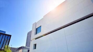 Sunlight and shadow on surface of white Concrete Building wall against blue sky background, Geometric Exterior Architecture in Minimal Street photography style photo