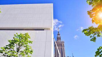 Modern white concrete building walls against blue sky. Eco architecture. Green trees and concrete office building. The harmony of nature and modernity. photo