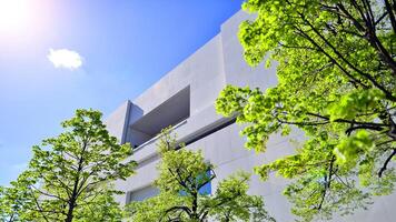 Modern white concrete building walls against blue sky. photo