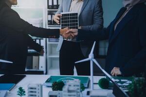 Two business executives, elegantly attired in suits, join hands in a gesture of unity, solidarity, and shared commitment towards a common goal or venture. photo