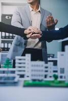 Two business executives, elegantly attired in suits, join hands in a gesture of unity, solidarity, and shared commitment towards a common goal or venture. photo