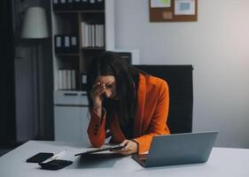 retrato de cansado joven negocio asiático mujer trabajo con documentos impuesto ordenador portátil computadora en oficina. triste, infeliz, preocupado, depresión, o empleado vida estrés concepto foto