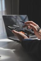 businessman working on desk office with using a calculator to calculate the numbers, finance accounting concept photo