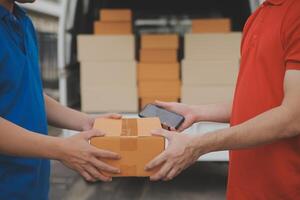 Asian delivery express courier young man use giving boxes to woman customer he wearing protective face mask at front home photo