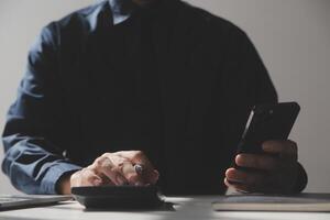 businessman working on desk office with using a calculator to calculate the numbers, finance accounting concept photo