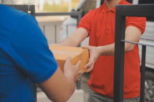 asiático entrega Rápido mensajero joven hombre utilizar dando cajas a mujer cliente él vistiendo protector cara máscara a frente hogar foto