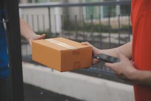 Asian delivery express courier young man use giving boxes to woman customer he wearing protective face mask at front home photo