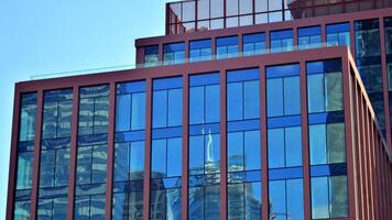 Glass building with transparent facade of the building and blue sky. Structural glass wall reflecting blue sky. Abstract modern architecture fragment. Contemporary architectural background. photo