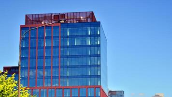 Glass building with transparent facade of the building and blue sky. Structural glass wall reflecting blue sky. Abstract modern architecture fragment. Contemporary architectural background. photo