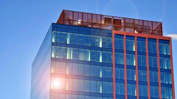 Glass building with transparent facade of the building and blue sky. Structural glass wall reflecting blue sky. Abstract modern architecture fragment. Contemporary architectural background. photo