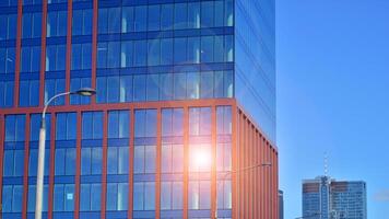 Glass building with transparent facade of the building and blue sky. Structural glass wall reflecting blue sky. Abstract modern architecture fragment. Contemporary architectural background. photo