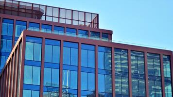 Glass building with transparent facade of the building and blue sky. Structural glass wall reflecting blue sky. Abstract modern architecture fragment. Contemporary architectural background. photo