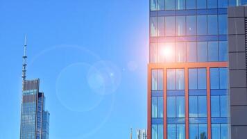Glass building with transparent facade of the building and blue sky. Structural glass wall reflecting blue sky. Abstract modern architecture fragment. Contemporary architectural background. photo