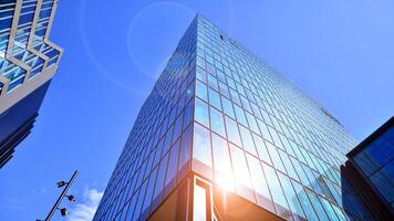 Glass building with transparent facade of the building and blue sky. Structural glass wall reflecting blue sky. Abstract modern architecture fragment. Contemporary architectural background. photo