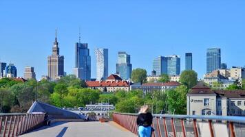 Warsaw, Poland. 11 April 2024. Bridge over the Vistula River intended only for pedestrians and cyclists. In the background, a panorama of the city with skyscrapers. photo