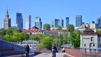 Warsaw, Poland. 11 April 2024. Bridge over the Vistula River intended only for pedestrians and cyclists. In the background, a panorama of the city with skyscrapers. photo