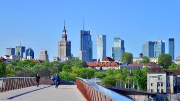 Warsaw, Poland. 11 April 2024. Bridge over the Vistula River intended only for pedestrians and cyclists. In the background, a panorama of the city with skyscrapers. photo