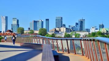 Warsaw, Poland. 11 April 2024. Bridge over the Vistula River intended only for pedestrians and cyclists. In the background, a panorama of the city with skyscrapers. photo