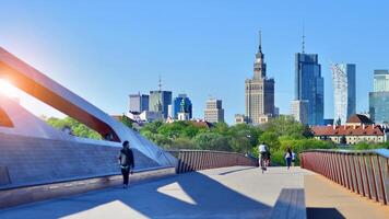 Warsaw, Poland. 11 April 2024. Bridge over the Vistula River intended only for pedestrians and cyclists. In the background, a panorama of the city with skyscrapers. photo