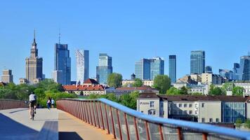 Warsaw, Poland. 11 April 2024. Bridge over the Vistula River intended only for pedestrians and cyclists. In the background, a panorama of the city with skyscrapers. photo