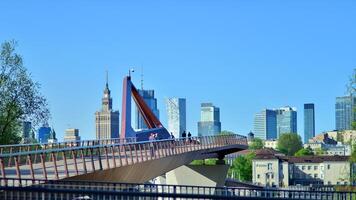 Warsaw, Poland. 11 April 2024. Bridge over the Vistula River intended only for pedestrians and cyclists. In the background, a panorama of the city with skyscrapers. photo