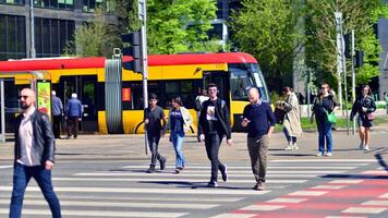 Warsaw, Poland. 11 April 2024. Crowd of people crossing street on traffic light zebra in the city at rush hour. Lifestyle in a big city in Europa. photo