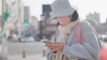 glimlachen vrouw gebruik makend van mobiel telefoon Aan stad straat video