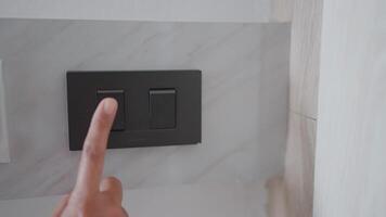 Woman's hand uses her finger to turn off the lights in her home to save energy and reduce global warming. video