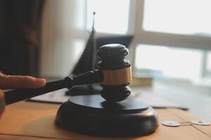 Business and lawyers discussing contract papers with brass scale on desk in office. Law, legal services, advice, justice and law concept picture with film grain effect photo