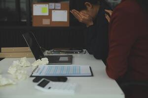 Stressed annoyed office employee manager having headache migraine at business meeting with his colleagues about business problem they have to solve. Stress at work or migraine concept. photo