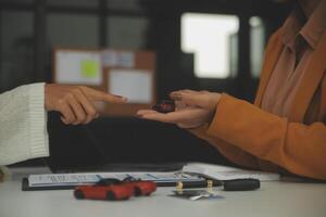 Insurance officers hand over the car keys after the tenant. have signed an auto insurance document or a lease or agreement document Buying or selling a new or used car with a car photo